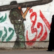 A Palestinian woman walks next to a grafitti of a Hamas militant carrying a rocket and an Israeli bus exploding, drawn on a wall in Rafah in the southern Gaza Strip on May 12, 2014. On May 15th, Palestinians mark the Nakba, or "catastrophe", when Israel was founded after the 1948 war, when hundreds of thousands of Palestinians fled or were forced to leave their homes. Photo: Abed Rahim Khatib/Flash90